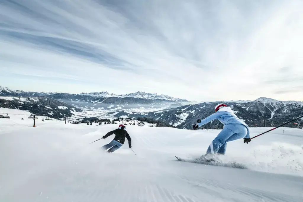 A scenic view of the snowy slopes in Salzburg, with skiers gliding down the piste during the winter season. The image captures the crisp, fresh snow and the beautiful mountainous landscape, creating a perfect winter sports atmosphere.