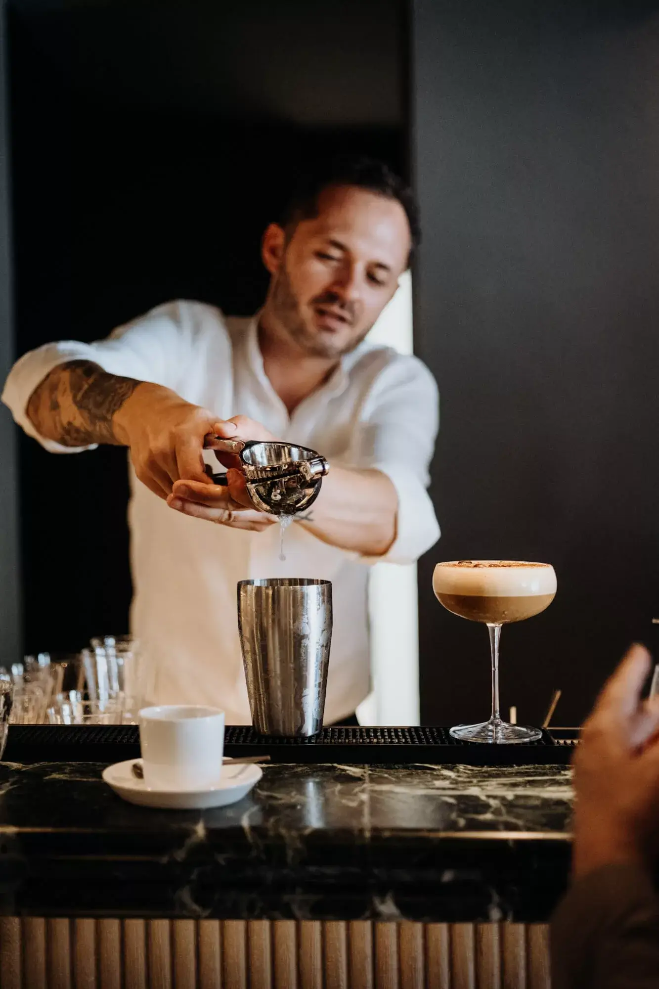 Bartender-squeezing-a-lime-directly-into-a-glass-at-the-counter