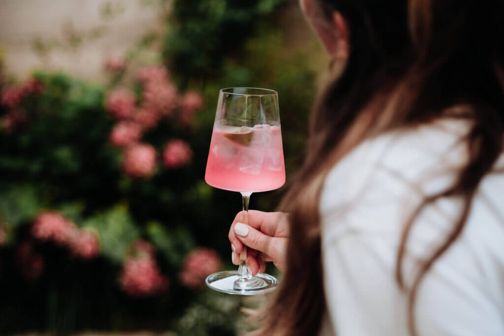 Woman enjoying a pink aperitif cocktail at The Hide Bar during a slow afternoon.
