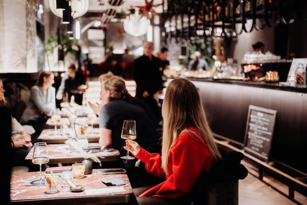 Woman in red sweater enjoys aperitif at Hide Bar's slow afternoon