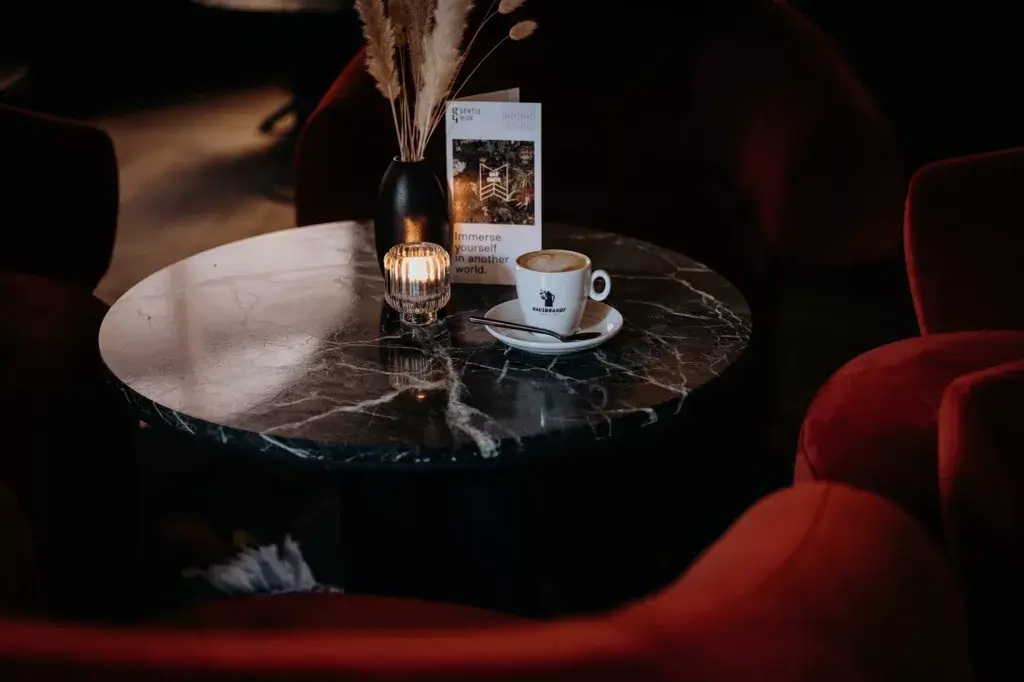 A cup of the best coffee in Salzburg, placed on a table at Gentle Hide, accompanied by a stylish setting and warm ambiance.