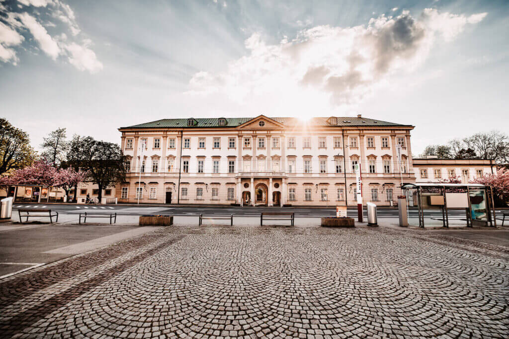 Schloss Mirabell, Salzburg's baroque palace, with sunbeams through clouds.