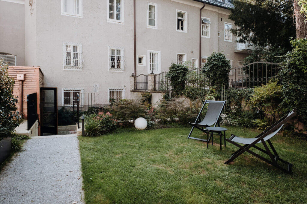 Verdant garden sanctuary with lounge chairs and lush greenery