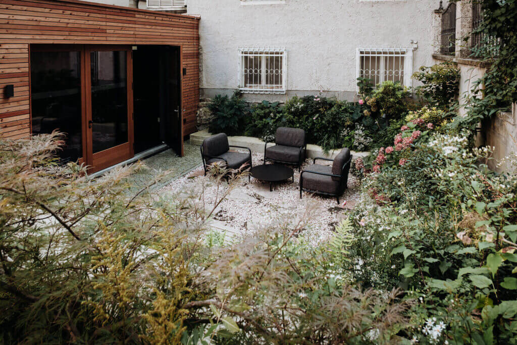 Cozy garden sanctuary with seating area and lush greenery.