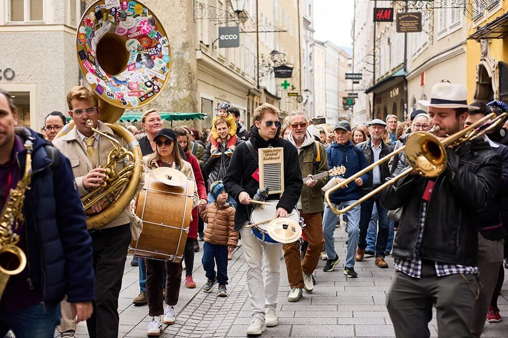 Street band plays jazz music in Salzburg, Austria, with sousaphone and trombones.
