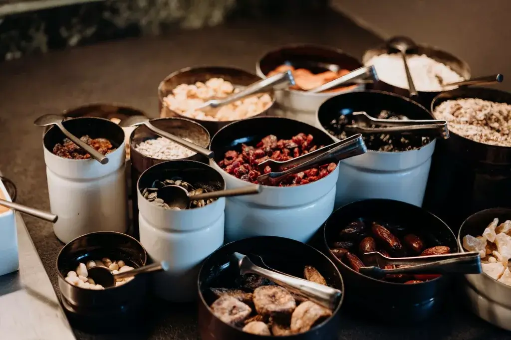 A selection of different cereals and fresh fruits, neatly arranged on a table, offering a healthy and vibrant breakfast choice.