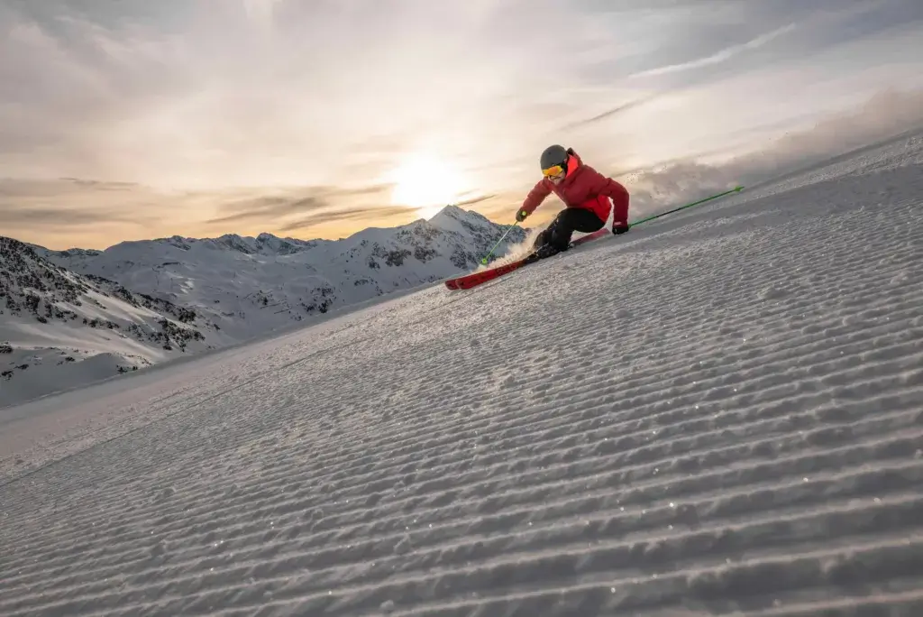 Skiing in Ski Amadé, with perfect slopes stretching across a stunning winter landscape. The smooth, well-maintained pistes offer an ideal setting for skiers of all levels, surrounded by snow-covered mountains and bright blue skies, creating a flawless winter sports experience.